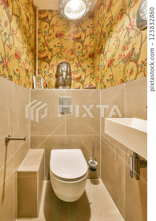 A stylish and modern bathroom featuring decorative wallpaper, elegant lighting, and sleek fixtures that create a luxurious atmosphere. A stylish and modern bathroom featuring decorative wallpaper, elegant lighting, and sleek fixtures that create a luxurious atmosphere. 123832860