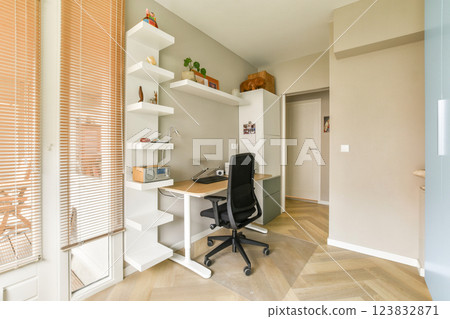 A stylish and organized home office setup featuring a sleek desk, comfortable chair, and minimalist shelves, perfect for productivity and aesthetics. 123832871