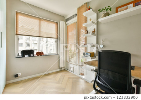 A contemporary office space featuring large windows, wooden flooring, and minimalist decor. The area is designed for productivity and comfort with stylish furniture. A contemporary office space featuring large windows, wooden flooring, and minimalist decor. The area is designed for productivity and comfort with stylish furniture. 123832900