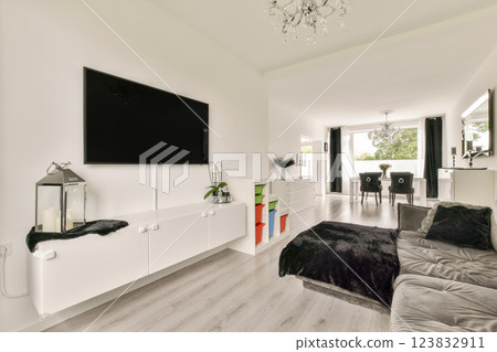 A stylish and spacious living room featuring minimalist decor, soft furnishings, and modern design elements. The bright space is complemented by natural light and elegant fixtures. A stylish and spacious living room featuring minimalist decor, soft furnishings, and modern design elements. The bright space is complemented by natural light and elegant fixtures. 123832911