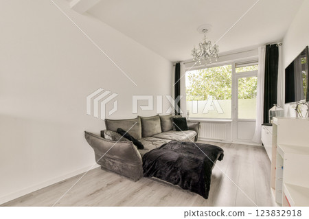 A sleek and modern living room showcasing minimalist decor, elegant furniture, and natural light filtering through large windows, creating a cozy atmosphere. 123832918