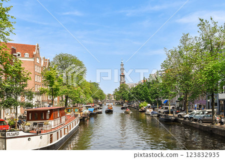 Lush trees frame this picturesque canal scene, with boats gliding through the water and historic buildings lining the banks, creating a vibrant urban atmosphere. Lush trees frame this picturesque canal scene, with boats gliding through the water and historic buildings lining the banks, creating a vibrant urban atmosphere. 123832935