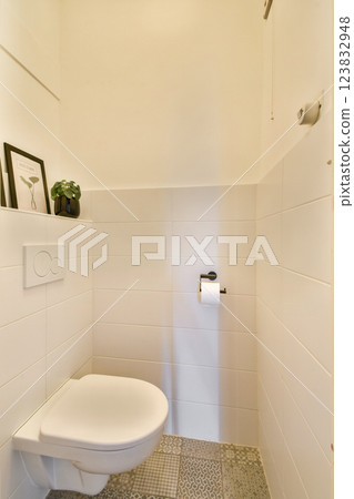 A sleek and modern bathroom design featuring a stylish toilet, minimalist decor, and subtle decor elements. The clean lines emphasize simplicity and functionality. 123832948