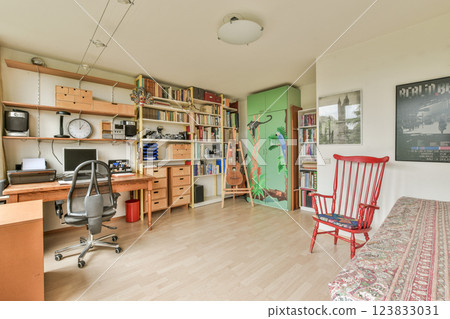 A stylish home office featuring a desk, bookshelves filled with books, and decorative elements. The room combines functionality with a welcoming atmosphere. 123833031