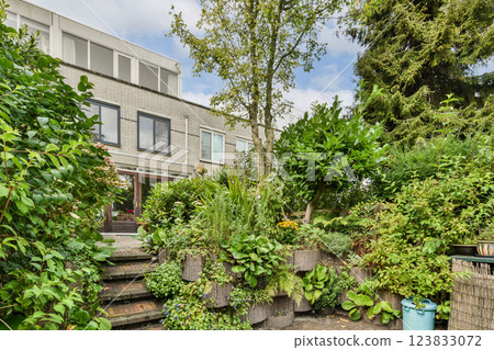 A vibrant garden featuring diverse greenery and stylish contemporary architecture, enhancing the natural beauty of the outdoor space. 123833072