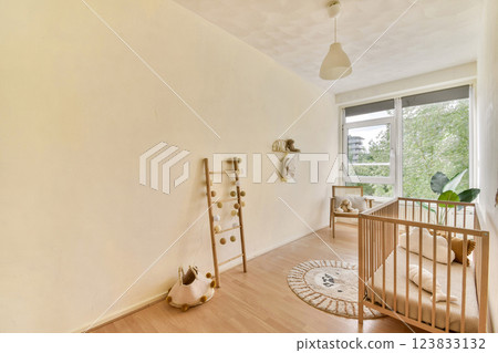 A serene minimalist interior showcasing a crib, decorative ladder, and soft lighting, enhanced by natural light streaming through large windows. A serene minimalist interior showcasing a crib, decorative ladder, and soft lighting, enhanced by natural light streaming through large windows. 123833132