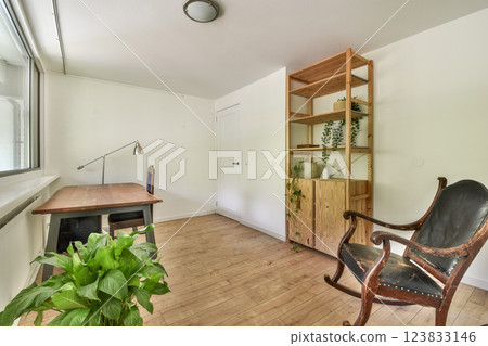 Bright and airy minimalist interior featuring wooden furniture, plants, and natural light illuminating the space, creating a serene atmosphere. 123833146