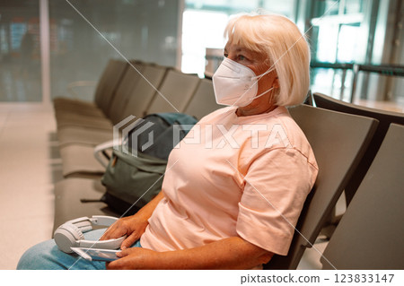 Mature 50s 60s woman with face masks sitting in a waiting room of a hospital or office. 123833147