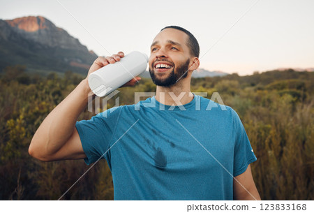 Runner, mountain nature and man drinking water after running. Break, relax and male from South Africa with refreshing liquid after training, workout or exercise on grass field for fitness or health. 123833168