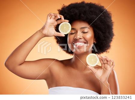 Fruit, beauty and skin of a black woman with smile holding a lemon on her face in brown studio background. Happy afro female model in healthy, vitamin c and natural skincare wellness for healthcare Fruit, beauty and skin of a black woman with smile holding a lemon on her face in brown studio background. Happy afro female model in healthy, vitamin c and natural skincare wellness for healthcare 123833241