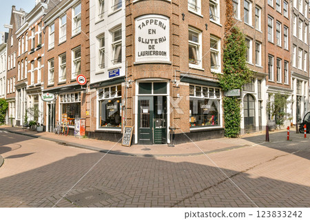A picturesque corner building featuring brick architecture and large windows, surrounded by greenery in a vibrant urban environment. A picturesque corner building featuring brick architecture and large windows, surrounded by greenery in a vibrant urban environment. 123833242