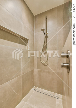 A sleek and contemporary shower featuring neutral-toned tiles and minimalist hardware, ideal for modern bathrooms. A sleek and contemporary shower featuring neutral-toned tiles and minimalist hardware, ideal for modern bathrooms. 123833274