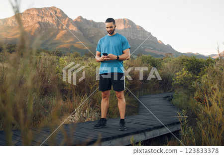 Exercise, man and phone in nature for wellness, health and sportswear on running path outdoor. Workout, healthy male or trainer for fitness, break or rest with smartphone in summer with digital watch 123833378
