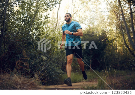 Fit man, nature run in forest and running for cardiovascular health or body wellness past green trees. Sports runner, cardio fitness training and working out doing offroad marathon workout exercise Fit man, nature run in forest and running for cardiovascular health or body wellness past green trees. Sports runner, cardio fitness training and working out doing offroad marathon workout exercise 123833425