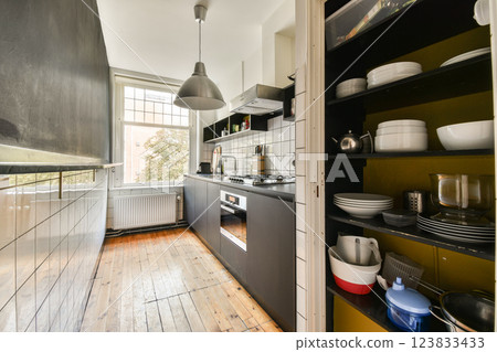 A contemporary kitchen featuring dark cabinetry, modern appliances, and spacious layout, perfect for cooking and entertaining guests. A contemporary kitchen featuring dark cabinetry, modern appliances, and spacious layout, perfect for cooking and entertaining guests. 123833433