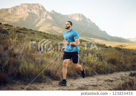 Running, fitness and mountain nature park road run of a man runner outdoor for exercise. Training, sport and workout of a athlete with fast energy and stamina on a walking and hiking dirt trail 123833453