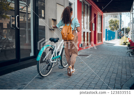 Bike, city and back view of black woman, walking on street or urban road outdoors. Exercise, fitness and female student on bicycle ride, eco friendly transportation and cycling on asphalt in town. 123833551