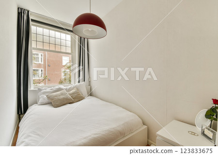 A well-designed cozy bedroom featuring natural light, modern decor, and a comfortable bed, perfect for relaxation and rest. 123833675