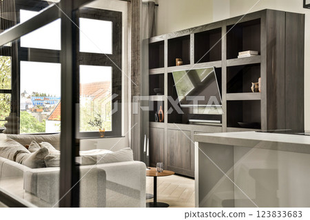 Stylish modern living room showcasing sleek furniture, large windows, and elegant decor that emphasizes comfort and aesthetics in a bright space. Stylish modern living room showcasing sleek furniture, large windows, and elegant decor that emphasizes comfort and aesthetics in a bright space. 123833683