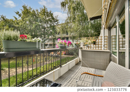 A beautifully arranged balcony featuring vibrant flowers and greenery, perfect for relaxation and enjoying nature in an urban setting. A beautifully arranged balcony featuring vibrant flowers and greenery, perfect for relaxation and enjoying nature in an urban setting. 123833776