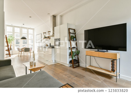 A stylish modern living space featuring a cozy seating area, large windows for natural light, and contemporary furniture design. Ideal for relaxation and socializing. A stylish modern living space featuring a cozy seating area, large windows for natural light, and contemporary furniture design. Ideal for relaxation and socializing. 123833820