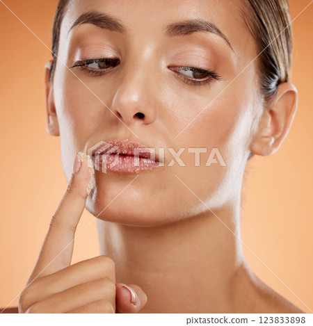 Face, beauty and lips, woman and scrub, natural makeup and skincare product advertising with orange studio background. Cosmetics, fresh and clean, facial and lip treatment, wellness and glow closeup 123833898