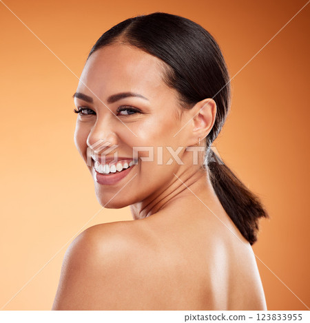 Face, beauty and skincare for woman with smile for facial health against a brown mockup studio background. Young model happy about natural wellness, clean teeth and dermatology with mock up space 123833955