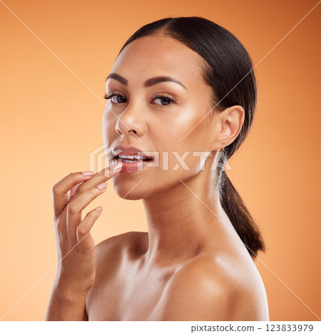 Woman with lip balm makeup in studio, portrait with skincare product advertising or natural sunscreen on face. Lip gloss on mouth, beauty model on orange background or moisturizer cream lipstick Woman with lip balm makeup in studio, portrait with skincare product advertising or natural sunscreen on face. Lip gloss on mouth, beauty model on orange background or moisturizer cream lipstick 123833979