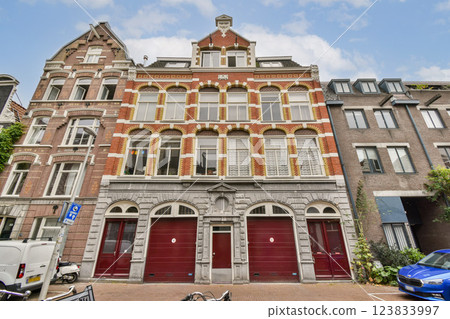 Elegant historic building showcasing intricate brickwork and arched windows, set against a clear blue sky in an urban landscape. 123833997