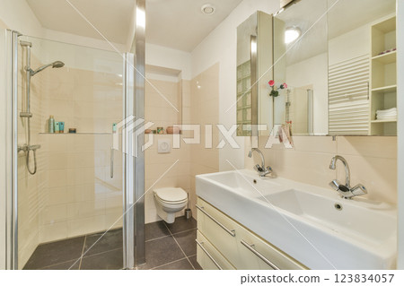 A sleek modern bathroom featuring a glass shower enclosure, minimalist sink, and elegant fixtures in a neutral color scheme, enhancing the overall aesthetic. A sleek modern bathroom featuring a glass shower enclosure, minimalist sink, and elegant fixtures in a neutral color scheme, enhancing the overall aesthetic. 123834057