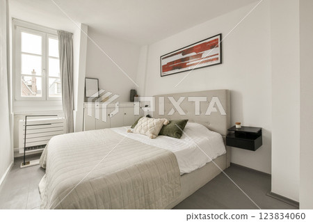 A sleek and minimalistic bedroom featuring neutral colors, a comfortable bed, and stylish decor. The design emphasizes simplicity and functionality in a cozy environment. A sleek and minimalistic bedroom featuring neutral colors, a comfortable bed, and stylish decor. The design emphasizes simplicity and functionality in a cozy environment. 123834060