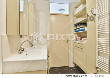 Stylish and minimalist bathroom featuring sleek cabinetry, organized towels, and contemporary fixtures, creating a vibrant yet serene ambiance. Stylish and minimalist bathroom featuring sleek cabinetry, organized towels, and contemporary fixtures, creating a vibrant yet serene ambiance. 123834092