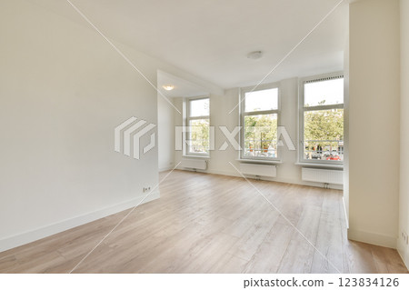 An inviting empty room featuring large windows that flood the space with natural light, showcasing clean lines and a fresh feel. An inviting empty room featuring large windows that flood the space with natural light, showcasing clean lines and a fresh feel. 123834126