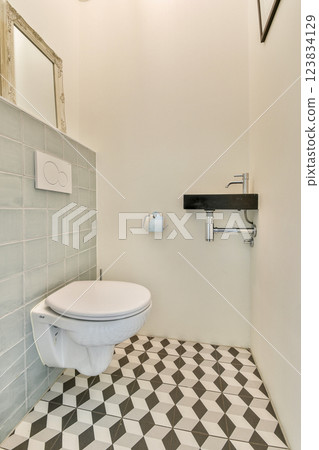A sleek and modern bathroom featuring a wall-mounted sink, patterned floor tiles, and minimalist design, emphasizing space and simplicity. A sleek and modern bathroom featuring a wall-mounted sink, patterned floor tiles, and minimalist design, emphasizing space and simplicity. 123834129