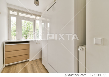 Bright and airy minimalist bedroom featuring sleek white cabinetry and natural wood accents, creating a serene and organized atmosphere. Bright and airy minimalist bedroom featuring sleek white cabinetry and natural wood accents, creating a serene and organized atmosphere. 123834138