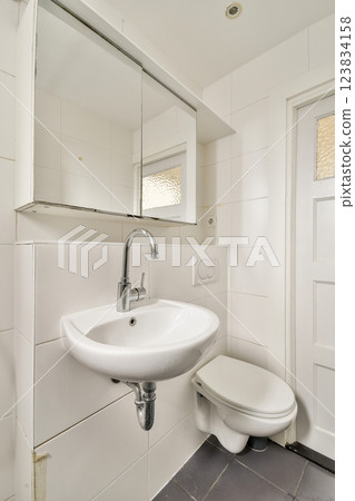 A sleek and contemporary bathroom featuring a minimalistic sink and toilet, highlighting the efficient use of space and clean lines. 123834158