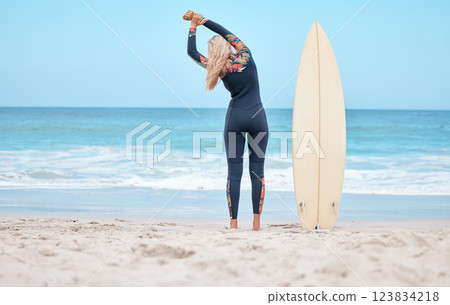 Surfing, stretching and woman surfer on beach standing by surfboard. Blue sky, ocean and girl ready to surf, doing stretch and water sports in Australia. Summer, wellness and fun activity in nature Surfing, stretching and woman surfer on beach standing by surfboard. Blue sky, ocean and girl ready to surf, doing stretch and water sports in Australia. Summer, wellness and fun activity in nature 123834218