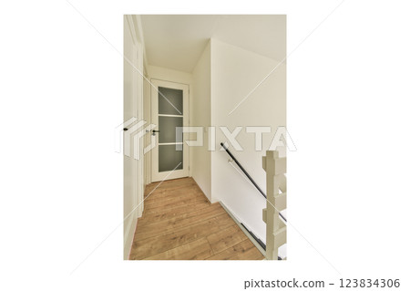 A contemporary indoor stairway showcasing a minimalist design with light walls and wooden flooring, creating a bright and airy atmosphere. 123834306