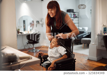 Hairdresser, barber and disability for child in wheelchair in salon, parlour or barbershop. Stylist, woman and happy for service to disabled kid with cerebral palsy in shop, store or small business 123834349