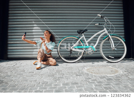 Bicycle, street and woman taking a selfie in a city blowing a kiss in photo or pictures in summer outdoors. Freedom, bike and young girl creating phone content for social media followers in holidays Bicycle, street and woman taking a selfie in a city blowing a kiss in photo or pictures in summer outdoors. Freedom, bike and young girl creating phone content for social media followers in holidays 123834362