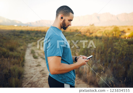 Man, phone and music earphones for fitness, training or exercise in nature environment, countryside park or grass field path. Runner, sports workout or 5g mobile technology for health data app or gps Man, phone and music earphones for fitness, training or exercise in nature environment, countryside park or grass field path. Runner, sports workout or 5g mobile technology for health data app or gps 123834555