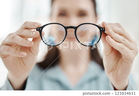 Eyes, vision and glasses with the hands of a woman optometrist holding spectacles during an eye test or exam. Frame, medical and insurance with a female optician showing prescription eyewear Eyes, vision and glasses with the hands of a woman optometrist holding spectacles during an eye test or exam. Frame, medical and insurance with a female optician showing prescription eyewear 123834631