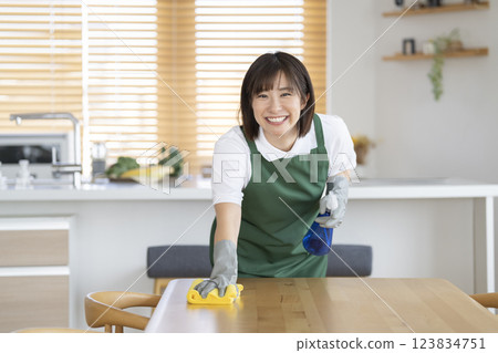Housekeeping image: A female cleaning staff member in her 30s smiling and looking at the camera 123834751
