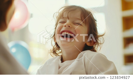 Joyful caucasian child laughing indoors with bright expression 123834927