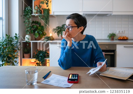 Stressed mature woman calculating expenses, managing debts and finances, planning family budget Stressed mature woman calculating expenses, managing debts and finances, planning family budget 123835119