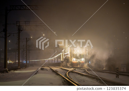 Retro Christmas steam train at night in the city on Christmas Eve and New Year in Russia. 123835374