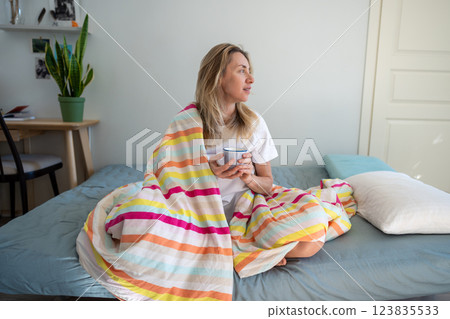 Relaxed woman in bed enjoying coffee and contemplation, resting on lazy morning, lead slow living Relaxed woman in bed enjoying coffee and contemplation, resting on lazy morning, lead slow living 123835533