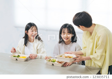 A woman serving lunch to a child A woman serving lunch to a child 123835711