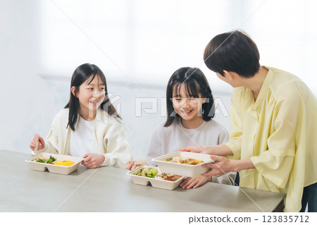 A woman serving lunch to a child A woman serving lunch to a child 123835712