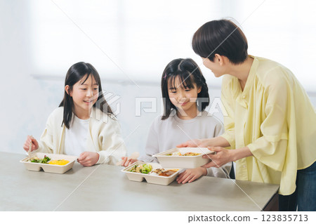 A woman serving lunch to a child A woman serving lunch to a child 123835713